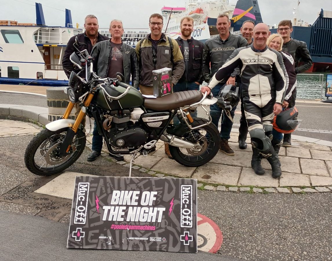 Group of men posing with the winning bike at Poole quay